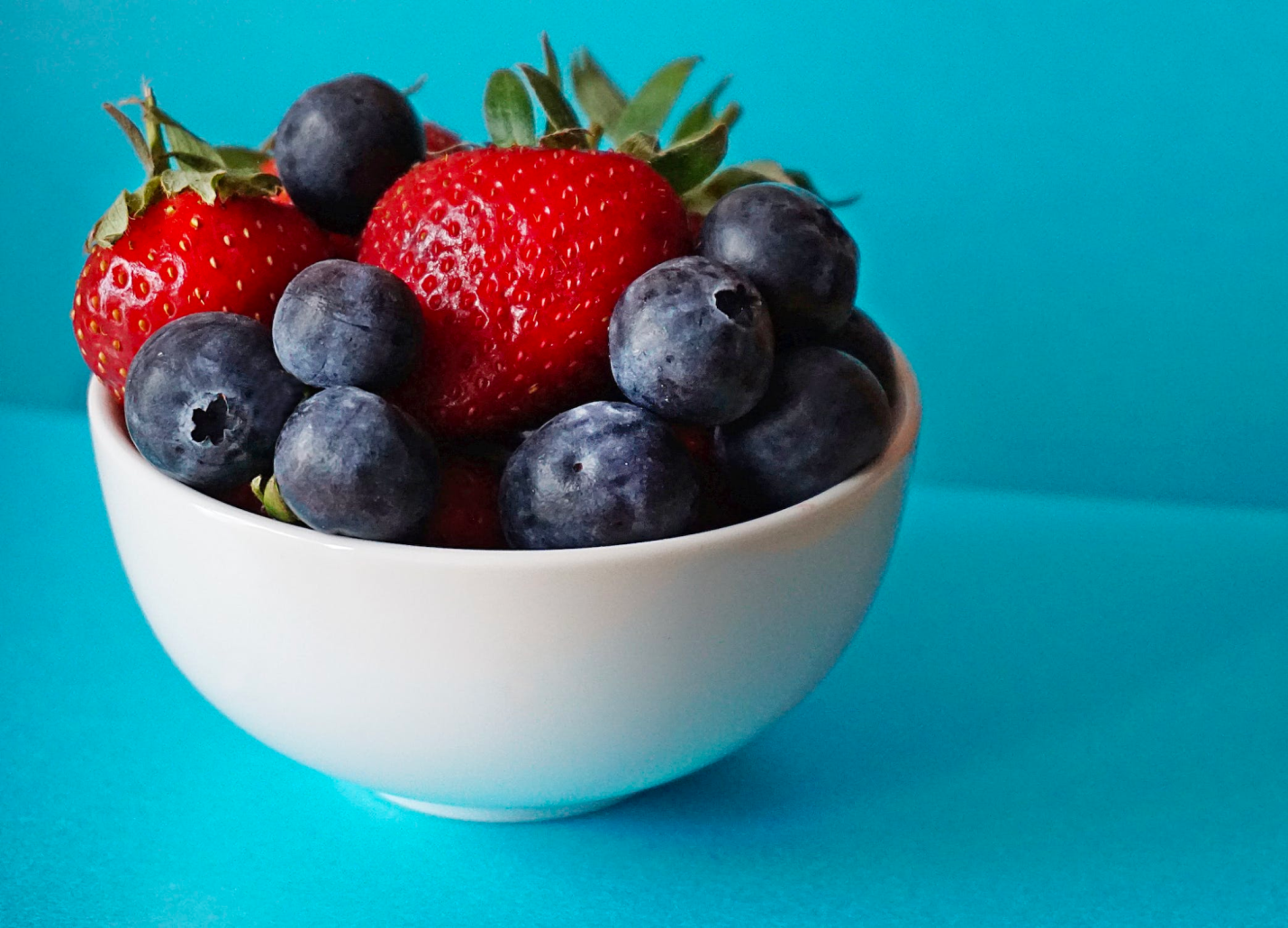 A bowl of various berries, including blueberries and strawberries.