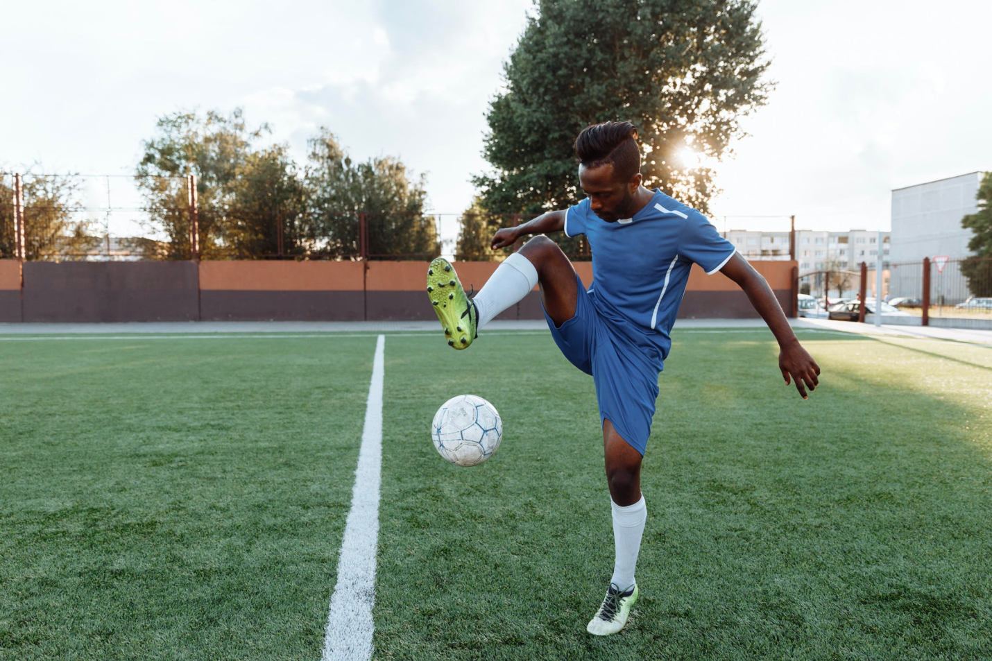 A healthy soccer player performs tricks while on the field